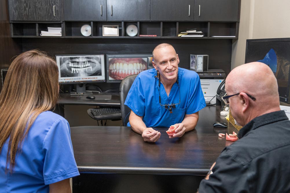 Dr David McFadden consulting patients at his desk